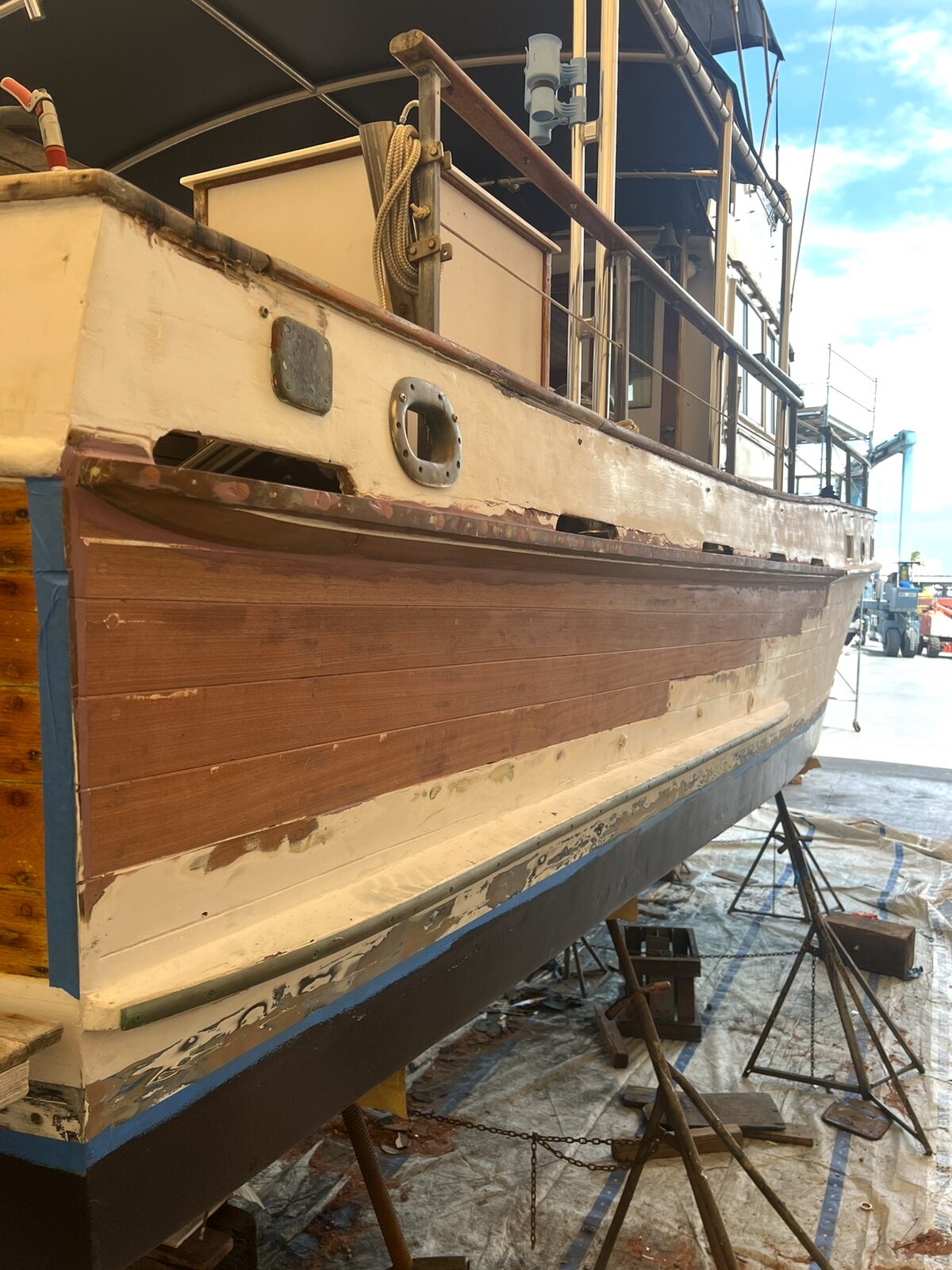 Wood and fiberglass repair area on the side of a boat
